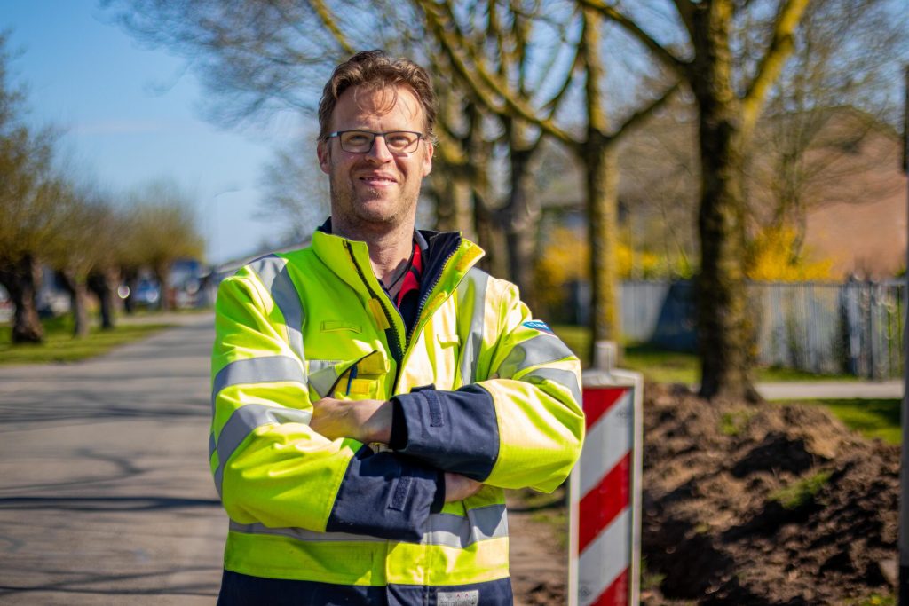 Uitvoerder bij Alliander die buiten bij de sleuf staat